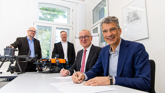 Prof. Dr. Antonio Krüger und Prof. Dr. Manfred Weisensee unterschreiben die Kooperationsvereinbarung, die die Zusammenarbeit zwischen Jade Hochschule und DFKI regelt. Im Hintergrund: Prof. Dr. Lars Nolle und Dr. Frederic Stahl 