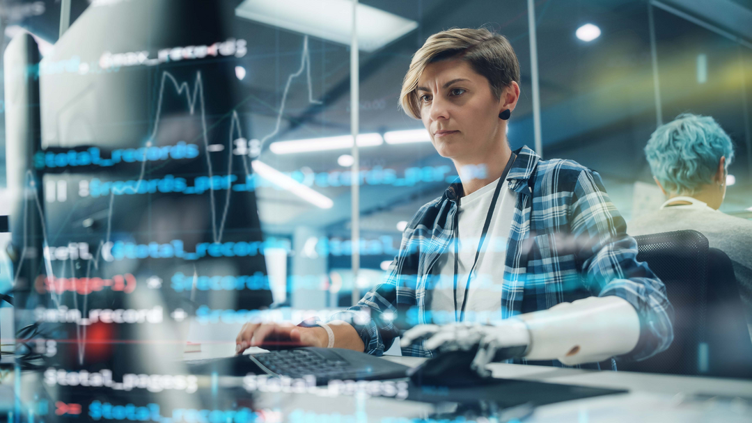 Eine Frau mit Armprothese benutzt einen Computer.