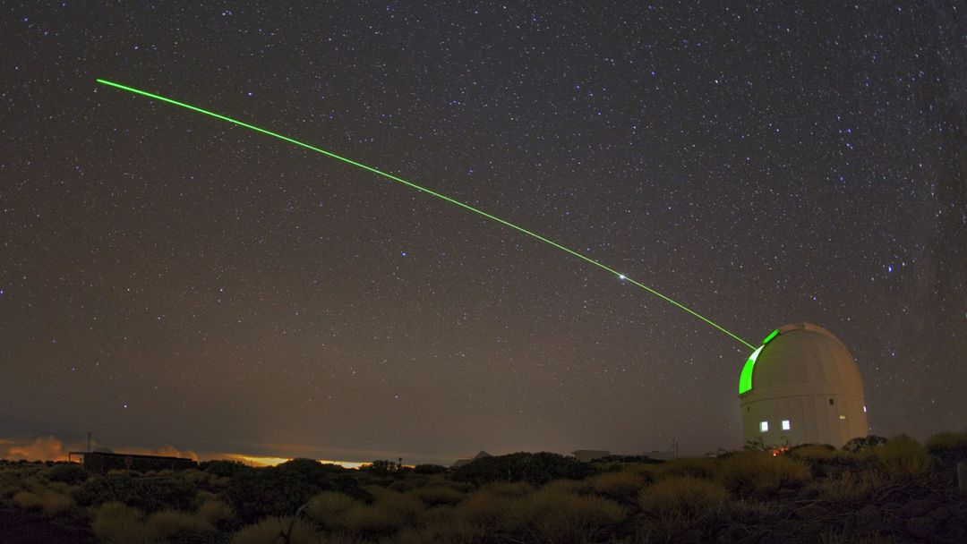 A visible green laser shone from ESA's Optical Ground Station (OGS).