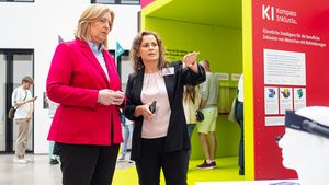 Susan Beudt, stellvertretende Leiterin des Educational Technology Lab am DFKI und Konsortialleiterin des Projekts KI-Kompass Inklusiv (r.) erläutert Bundesministerin Bärbel Bas (l.), wie KI-gestützte Assistenztechnologien Menschen mit Behinderungen im Arbeitsleben unterstützen können